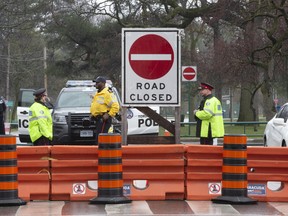 Police stand guard outside Toronto's High Park entrances on Thursday, April 30, after the popular west-end park was closed to prevent further spread of COVID-19. Crowds would ordinarily assemble in large numbers to enjoy the cherry blossoms at this time of year.