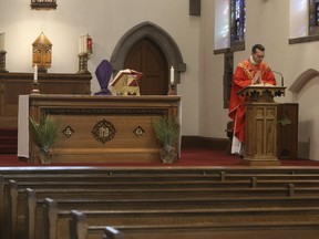 Father Peter Turrone performs Palm Sunday mass before an empty church at the Newman Centre Catholic chapel on St. George St. in Toronto. It was the beginning of Holy Week leading up to Good Friday and Easter next Sunday. (Jack Boland/Toronto Sun/Postmedia Network)