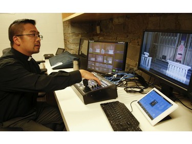 Deacon Michael Corpus checks out his camera and video angles in the basement of  St. Michael's Cathedral Basilica on Bond St. Before simulcasting the Good Friday service on Youtube and Facebook Live to those who couldn't attend mass because of COVID19 pandemic on Friday April 10, 2020. Jack Boland/Toronto Sun/Postmedia Network