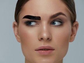 Beauty makeup. Woman coloring eyebrow with brow gel tint