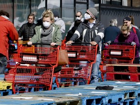Due to COVID-19, shoppers line up in front of Loblaws at the Leslie St. location in Toronto, separated in rows by stacked wooden pallets on Thursday, April 9, 2020. (Veronica Henri/Toronto Sun/Postmedia Network)