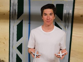 Xavier McKeever shows off two of what’s left of his fleet of miniature airplanes. Behind him, tacked up to the wall of his family’s basement is a replica plywood runway of the Canmore, Alta., airport, made for him by his grandfather.  SUPPLIED PHOTO
