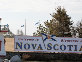 Nova Scotia flags are lowered on the New Brunswick/Nova Scotia border a day after a mass shooting by Gabriel Wortman, in Fort Lawrence.