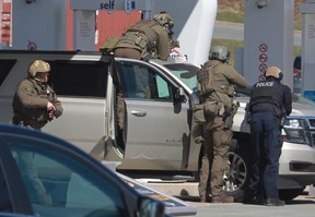 RCMP officers confront the mass-slaying suspect at a gas station in Enfield, N.S. on April 19, 2020.