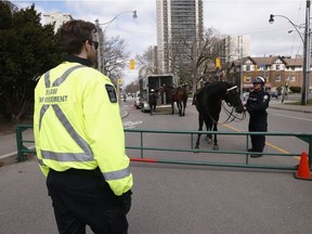 Toronto Police mounted unit and Toronto by-law enforcement officers were at the Bloor St. West entrance  High Park making sure about social distancing and telling people to move along and not gather in areas.  on Sunday April 5, 2020.