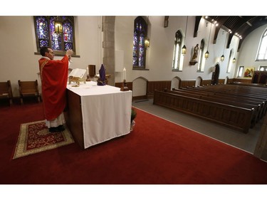 Father Peter Turrone performs Palm Sunday mass at the Newman Centre Catholic chapel on St. George St. before an empty church. It is a the beginning of Holy Week leading up to Good Friday and Easter next Sunday on Sunday April 5, 2020. Jack Boland/Toronto Sun/Postmedia Network