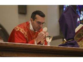 Father Peter Turrone performs Palm Sunday mass and the Eucharist at the Newman Centre Catholic chapel on St. George St. before an empty church. It is a the beginning of Holy Week leading up to Good Friday and Easter next Sunday on Sunday April 5, 2020. Jack Boland/Toronto Sun/Postmedia Network