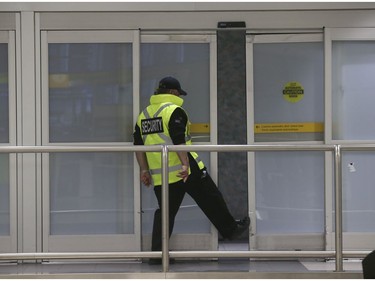 A security officer pushes open the arrival doors at Pearson International Terminal 1 on Thursday April 2, 2020. Jack Boland/Toronto Sun/Postmedia Network