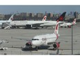 Air Canada planes are parked off in a corner of the tarmac outside of Terminal 3 on Thursday, April 2, 2020.