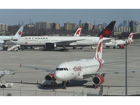 Air Canada planes are parked off in a corner of the tarmac outside of Terminal 3 on Thursday, April 2, 2020.