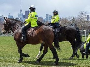 Officers on horses patrol a Toronto greenspace.