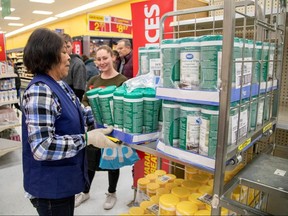 People wait as an employee restocks a shelf with disinfectant wipes at a Walmart Supercentre amid coronavirus fears spreading in Toronto March 13, 2020. (REUTERS/Carlos Osorio)
