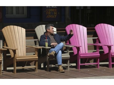 Enjoying a coffee, smoking a Cuban cigar and taking in some sunshine along King St. W. In front of Metro Hall's David Pecaut Square in Wednesday April 1, 2020. Jack Boland/Toronto Sun/Postmedia Network