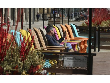 Enjoying a coffee, smoking a Cuban cigar and taking in some sunshine along King St. W. In front of Metro Hall's David Pecaut Square in Wednesday April 1, 2020. Jack Boland/Toronto Sun/Postmedia Networka