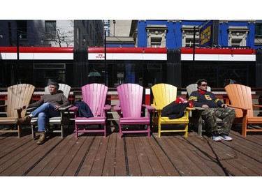 Enjoying a coffee, smoking a Cuban cigar and taking in some sunshine along King St. W. In front of Metro Hall's David Pecaut Square in Wednesday April 1, 2020. Jack Boland/Toronto Sun/Postmedia Network