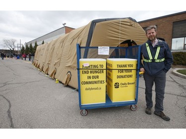 Neil Hetherington CEO of the Toronto Daily Bread Food Bank poses outside their location on  New Toronto St. in Etobicoke. The TDBFB has set up an inflatable medical tent outside its facility along with a conveyor belt to get food to its clients since they cannot come in the building  on Wednesday April 8, 2020. Jack Boland/Toronto Sun/Postmedia Network