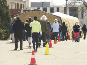 The lineup to the Toronto Daily Bread Food Bank on New Toronto St. in Etobicoke on April 8, 2020. The TDBFB set up an inflatable medical tent outside its facility along with a conveyor belt to get food to its clients.