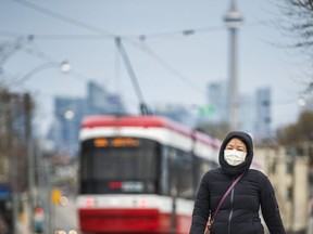 A masked pedestrian along Dundas St. W., near Landsdowne Ave. in Toronto April 29, 2020.