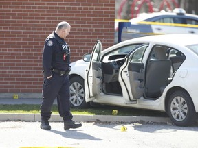 Toronto Police  gather evidence from around a four-door white Honda in the parking lot of the Leaside Park outdoor pool facility on Monday, April 6, 2020 after a person was shot to death Sunday. Jack Boland/Toronto Sun