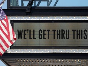 A flag flies beside the marquee at The Anthem music venue reading "We'll Get Thru This" referring to the battle against the coronavirus pandemic in Washington April 2, 2020. (REUTERS/Kevin Lamarque)