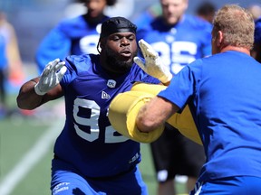 Drake Nevis (left) looks for a way around defensive line coach Glenn Young during a Blue Bombers practice last year. The two will be reunited in Toronto this year. (Kevin King/Postmedia Network)