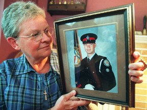 In this March 1999 file photo, Ann Hancox holds up a photo of her slain son, Det-Const.  Bill Hancox.