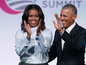 (FILES) In this file photo taken on October 31, 2017, former US President Barack Obama and First Lady Michelle Obama arrive at the Obama Foundation Summit in Chicago, Illinois. Barack and Michelle Obama have entered into a multi-year agreement to produce films and series with Netflix, the world's leading internet entertainment service announced on May 21, 2018. The former first couple have launched Higher Ground Productions to produce a variety of content for the video streamer, possibly including scripted series, documentaries and features.  / AFP PHOTO / Jim YoungJIM YOUNG/AFP/Getty Images