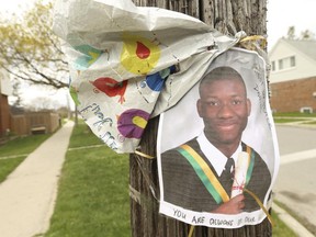 A graduation picture and flowers were left near the murder scene where Daniel Boima, 23, was shot dead.
