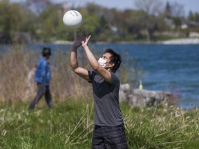 Cyrus Bugarin is pictured as he plays with a volleyball at Colonel Samuel Smith Park in Toronto on Sunday.