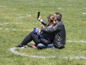 A couple sit in a social-distancing circle at Trinity Bellwoods Park on May 31, 2020.