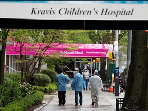 Health-care workers stand near the entrance to the Mount Sinai Kravis Children's Hospital as the outbreak of the coronavirus disease (COVID-19) continues in the Manhattan borough of New York, May 8, 2020.