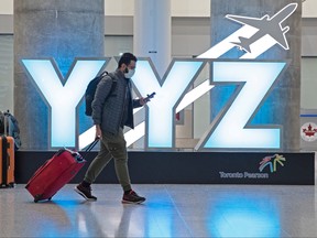 A traveller passes a YYZ airport code sign in the international arrival lounge amid a growing global number of coronavirus cases at Pearson airport in Toronto March 13, 2020.