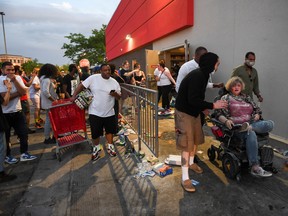 Protesters attend a woman who allegedly stabbed looters before stabbing herself in an effort to stop the looting, near the Minneapolis Police third precinct, where demonstrators gathered after a white police officer was caught on a bystander's video pressing his knee into the neck of African-American man George Floyd, who later died at a hospital, in Minneapolis, Minnesota.