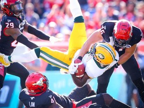 Edmonton Eskimos Natey Adjei is tackled by Cordarro Law and Cory Greenwood Calgary Stampeders during CFL football in Calgary on Monday, September 2, 2019. Al Charest/Postmedia
