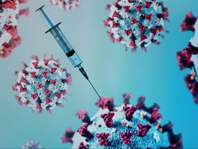 A syringe is pictured on an illustration representation of COVID-19, the disease caused by the novel coronavirus in Paris on May 18, 2020.