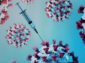 A syringe is pictured on an illustration representation of COVID-19, the disease caused by the novel coronavirus in Paris on May 18, 2020.