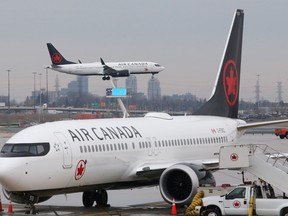 An Air Canada Boeing 737 MAX 8 from San Francisco approaches for landing at Toronto Pearson International Airport over a parked Air Canada Boeing 737 MAX 8 aircraft in Toronto.