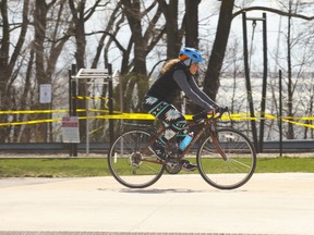 A cyclist gets in some exercise along the Martin Goodman Trail near the Argo Rowing club past taped-off lakeside parkland on Thursday, April 9, 2020.