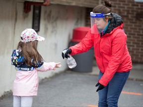 A student has her hands sanitized in the schoolyard, as schools outside the greater Montreal region begin to reopen their doors amid the coronavirus disease (COVID-19) outbreak, in Saint-Jean-sur-Richelieu, Quebec, Canada May 11, 2020. (Christinne Muschi/REUTERS)