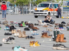 A person takes pictures of shoes placed, in place of live participants, by environmental activists of Swiss Klimastreik Schweiz movement to demonstrate against climate change in Zurich, Switzerland April 24, 2020.