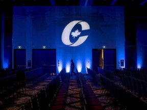 A man is silhouetted walking past a Conservative Party logo before the opening of the Party's national convention in Halifax on Thursday, August 23, 2018.