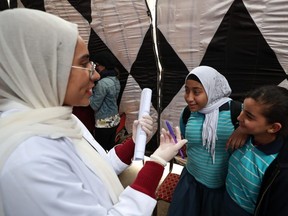 An Egyptian doctor gives medical advice to girls about Female Genital Mutilation (FGM) during an awareness campaign in Giza on February 18, 2020.