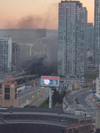 Smoke fills the skyline after a blaze at a homeless camp under the Gardiner Expressway on May 20, 2020.