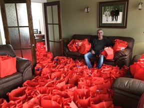 Collingwood resident Chris Dopp is surrounded by 100 food parcel giveaway bags he will donate to those in need due to the COVID-19 pandemic.