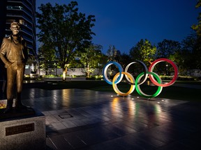 A bronze statue of Pierre de Coubertin (left), founder of the International Olympic Committee, and the Olympic Rings are displayed at Japan Sport Olympic Square in Tokyo. The Olympics have been put off until next summer.