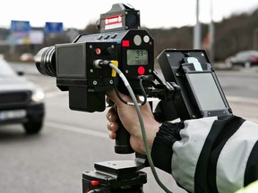 A police officer checks traffic for speeders.