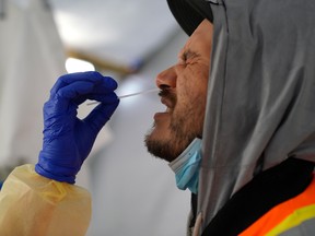 Provincial health workers perform coronavirus disease (COVID-19) nasal swab tests on Raymond Robins of the remote First Nation community of Gull Bay, Ont., April 27, 2020.