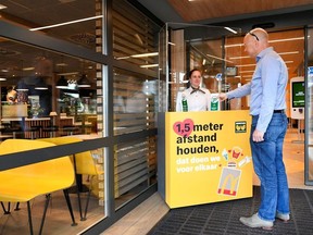 A man takes a number at a prototype location of fast food giant McDonald's for restaurants which respect the 1.5m social distancing measure, amid the coronavirus disease (COVID-19) outbreak, in Arnhem, Netherlands, May 1, 2020.