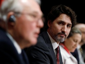 Canada's Prime Minister Justin Trudeau listens to Minister of Public Safety and Emergency Preparedness Bill Blair during a news conference on Parliament Hill in Ottawa, Ontario, May 1, 2020.