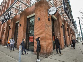 People line up at the LCBO on Spadina Ave., at Front St. W.,  in downtown Toronto, Ont. on Friday, May 1, 2020.